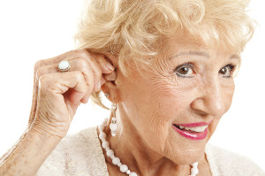 Senior Woman Inserts Hearing Aid
