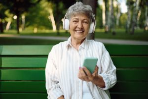 old-woman-in-headphones-listens-to-music-on-bench-2022-01-18-23-59-57-utc (1)